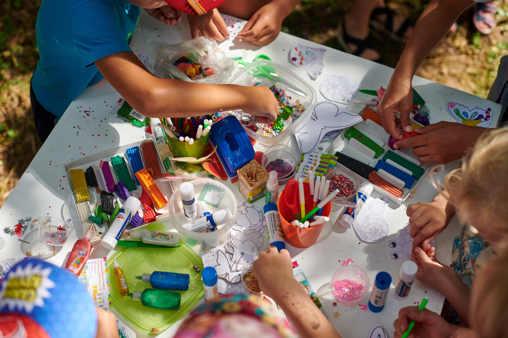 Children paper crafting with parents in outdoor children party, painting, molding of plasticine